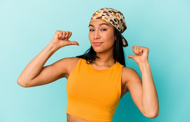 Young Venezuelan woman isolated on blue background feels proud and self confident, example to follow.