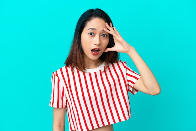 Young Vietnamese woman isolated on blue background has realized something and intending the solution