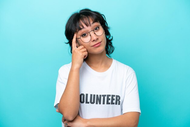 Young volunteer Argentinian woman isolated on blue background thinking an idea