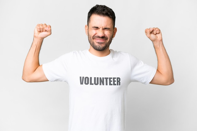 Young volunteer caucasian man over isolated white background doing strong gesture