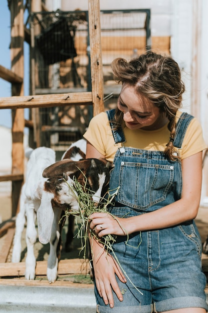 Young volunteer feeding baby goats