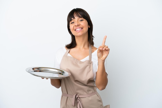 Young waitress with tray isolated on white background showing and lifting a finger