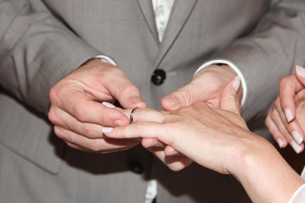 Young wedding couple exchange wedding rings