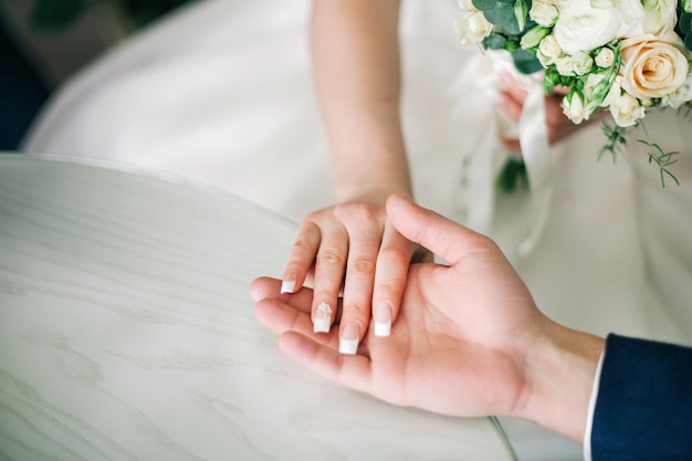 Young wedding couple holding hands