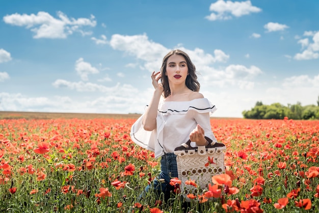 Young  woman alone at poppy in field summer day, lifestyle