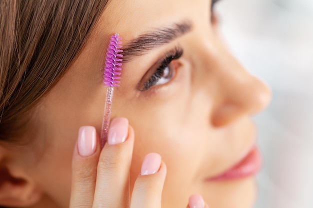 Young woman applied mascara to her lashes