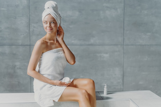 Young woman applying cream for spa treatment