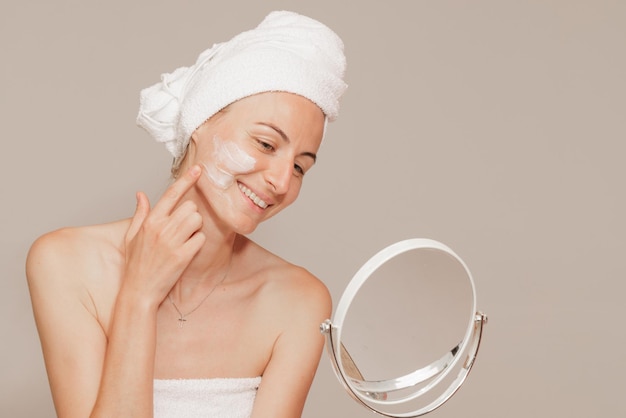 Young woman applying moisturizer