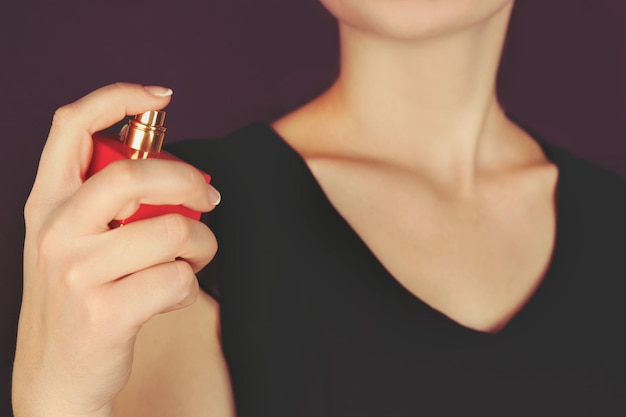 Young woman applying perfume on her neck