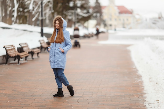 Young woman are walking in the winter park.