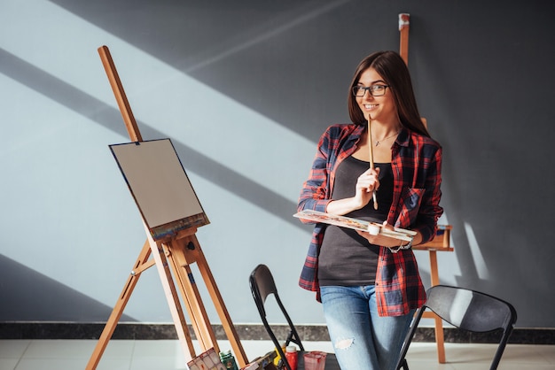 Young woman artist painting a picture