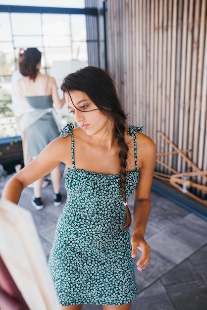 Young woman artist paints with a spatula on the canvas