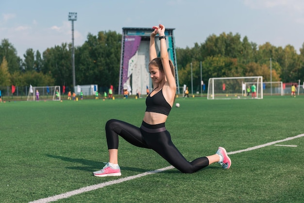 Young woman athlete is exercising at the stadium outdoors