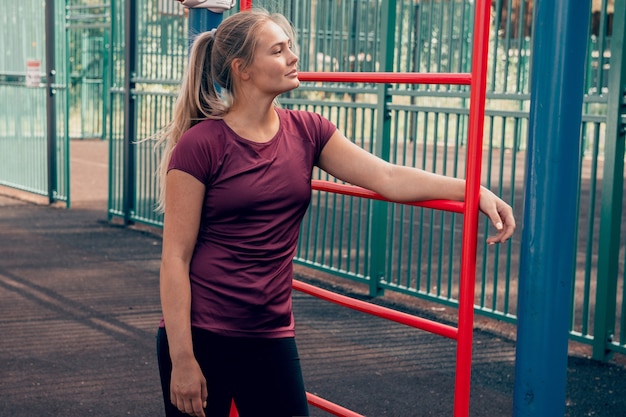 young woman athlete posing at sports ground