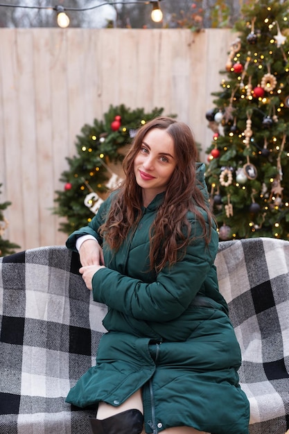 Young woman on background of Christmas tree with gifts outdoor Backyard decoration new year