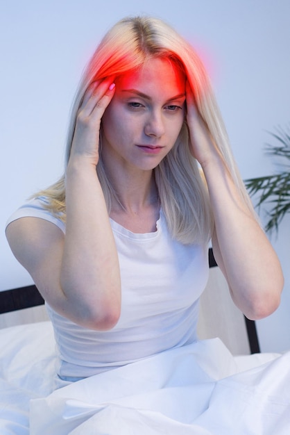 Young Woman in bad with hand on head for pain in head Suffering migraine