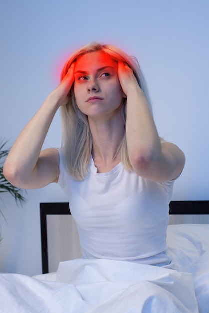 Young Woman in bad with hand on head for pain in head Suffering migraine