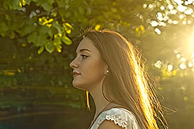 A young woman bathed in the golden light of sunset her hair glowing