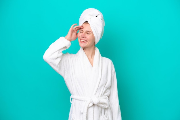 Young woman in a bathrobe isolated on blue background has realized something and intending the solution