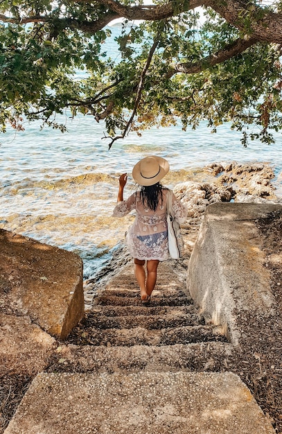 Photo young woman in beach clothes on stairs by sea summer lifestyle vacation