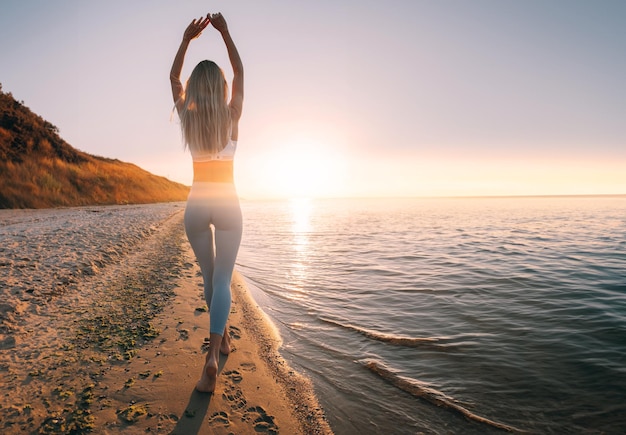 Young woman on the beach in a tracksuit with