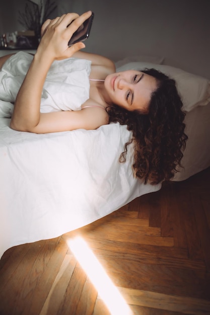 Young woman in bed morning light from the window