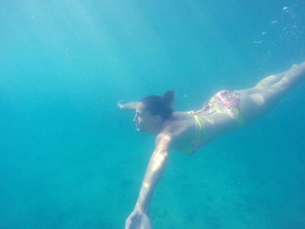 Young woman in bikini swimming undersea