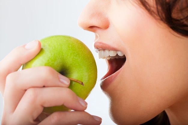 Young woman bites in a fresh and healthy apple