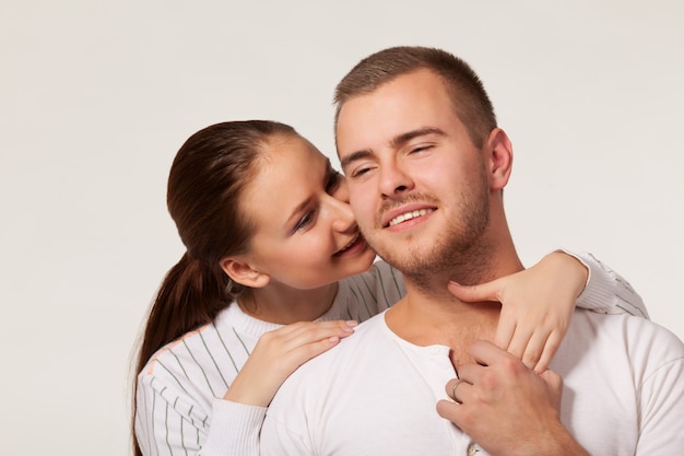 Young woman biting boyfriend ear.