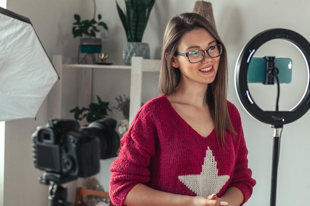 Young woman blogger getting ready to shoot video for vlog backstage of camera setting