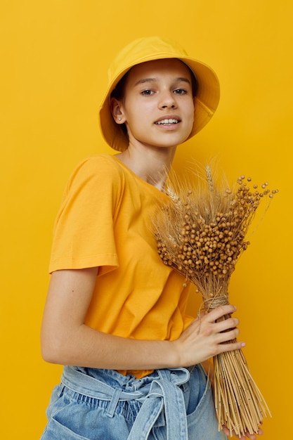 Young woman a bouquet of dried flowers in hands Youth style casual wear in Hat