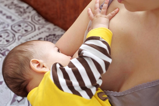 Young woman breastfeeding her baby at home Milk from mother's breast is a natural medicine to baby Mother day bonding concept with newborn baby nursing