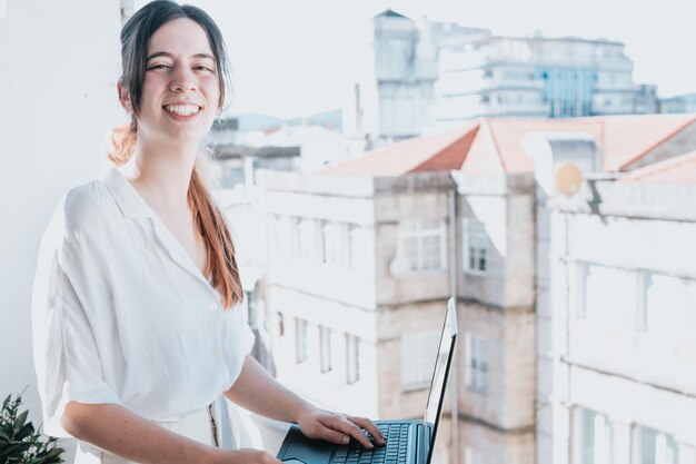 Young woman businesswoman freelancer using laptop for work outdoors on a balcony Freelance work vacations business people technologies distance studying elearning lifestyle meeting online