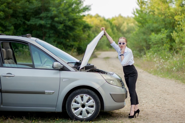 Young woman by the roadside after her car has broken down