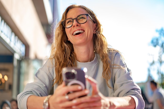 Young woman in a cafe reading a text message from her mobile phone