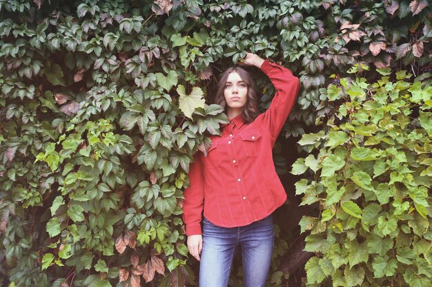 Young woman in casual clothes on green leaves background