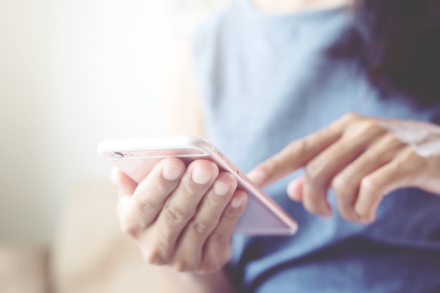 Young woman casual wear close up hand using on cell phone during rest on sofa