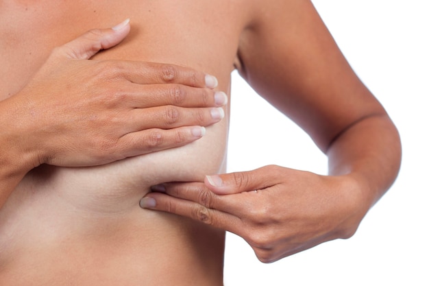 Young woman checking breast (auto self exam) for anomalies, nodes or weird lumps for breast cancer.