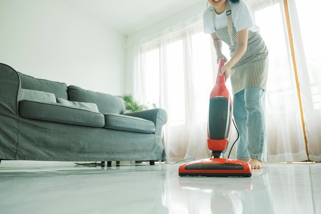 Young woman cleaning house with vacuum cleaner