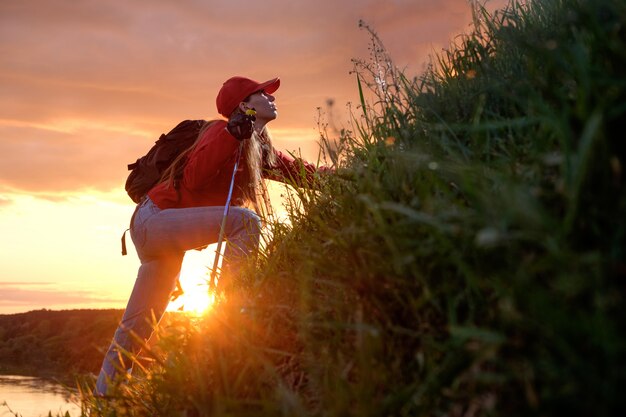 Young woman climbing over hills