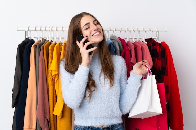 Young woman in a clothing store with a mobile