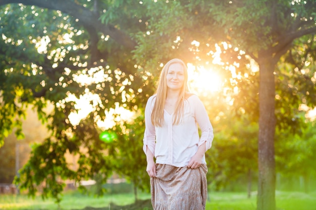 A young woman collects fruit from the tree at dawn