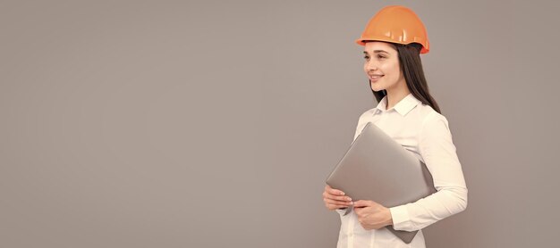 Young woman construction manager Woman builder isolated portrait with protect helmet and laptop