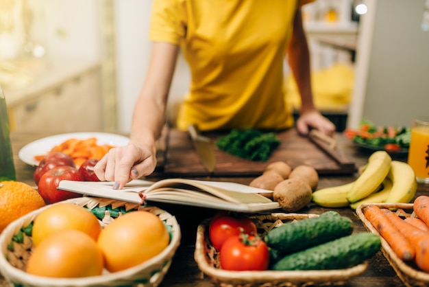 Young woman cooking on recipes, healthy bio food preparing.