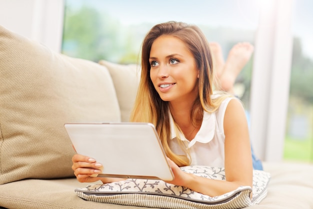 young woman on couch with tablet