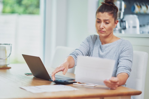 Young woman counting home budget with bills