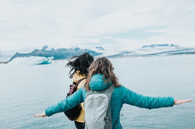 Young woman couple of travelers at the vatnajokull glacier having a fun day exploring Iceland