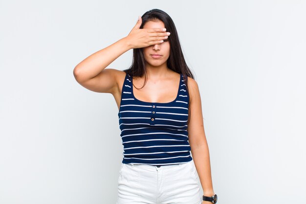 Young woman covering eyes with one hand