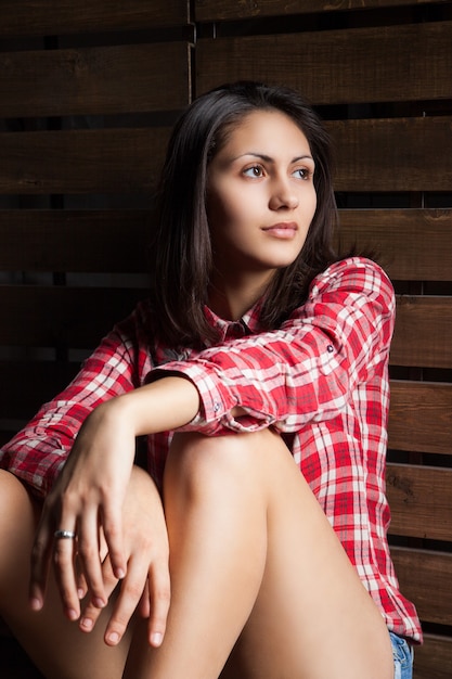 Young woman in cowboy clothes over wood