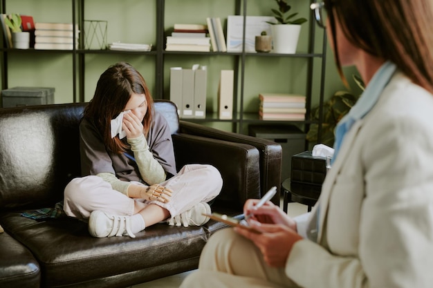 Photo young woman crying in counseling session sitting on couch